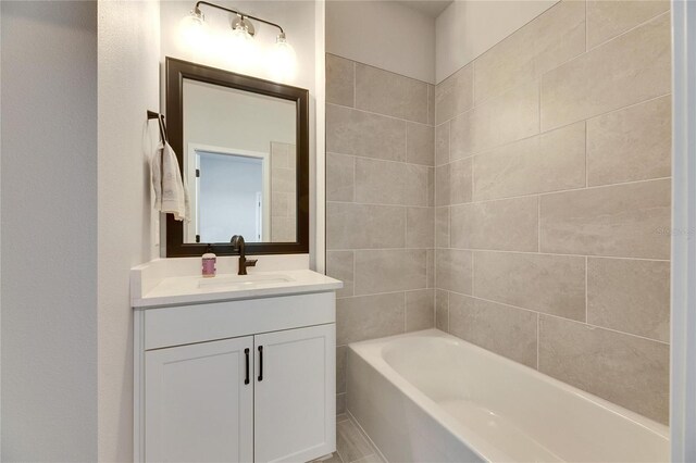 bathroom featuring tiled shower / bath combo and vanity