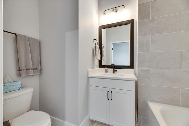 bathroom featuring toilet, vanity, and a tub to relax in