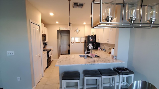 kitchen featuring white cabinets, hanging light fixtures, black appliances, and kitchen peninsula