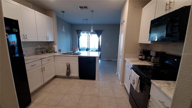 kitchen featuring kitchen peninsula, white cabinets, decorative light fixtures, and black appliances