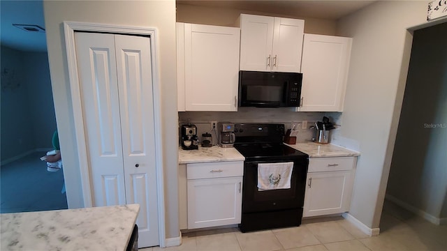 kitchen with light stone countertops, light tile patterned floors, black appliances, tasteful backsplash, and white cabinetry