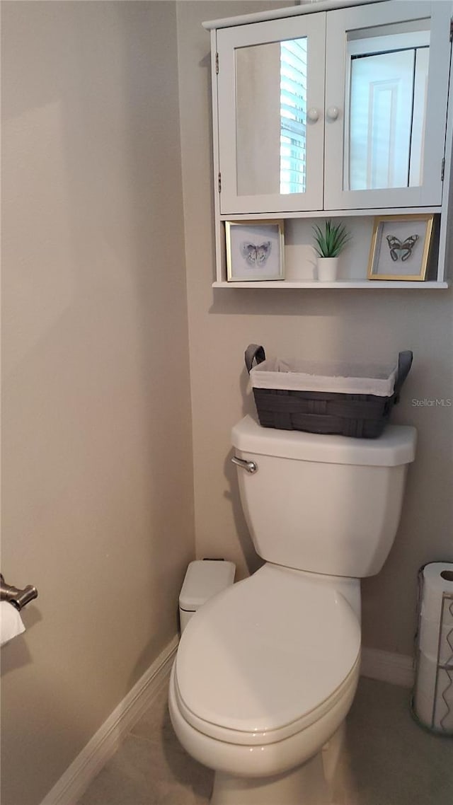 bathroom with toilet and tile patterned flooring