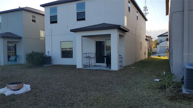 back of property featuring central AC unit and a lawn