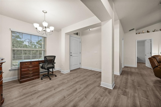 office featuring lofted ceiling, hardwood / wood-style floors, and a chandelier