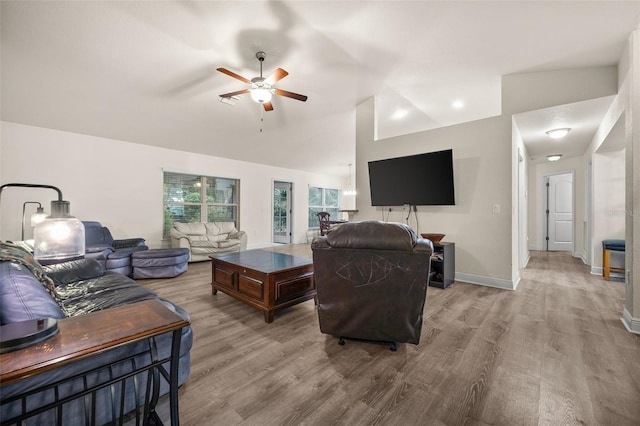 living room featuring ceiling fan, lofted ceiling, and light hardwood / wood-style floors