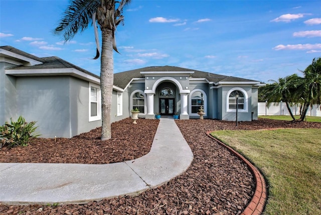 ranch-style house with a front yard and french doors