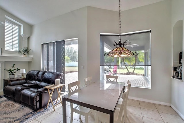 dining room featuring ceiling fan, light tile patterned floors, a healthy amount of sunlight, and lofted ceiling