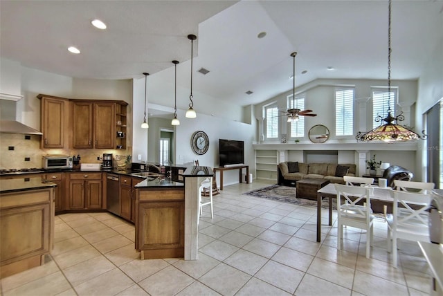 kitchen featuring decorative light fixtures, a kitchen bar, backsplash, kitchen peninsula, and ceiling fan