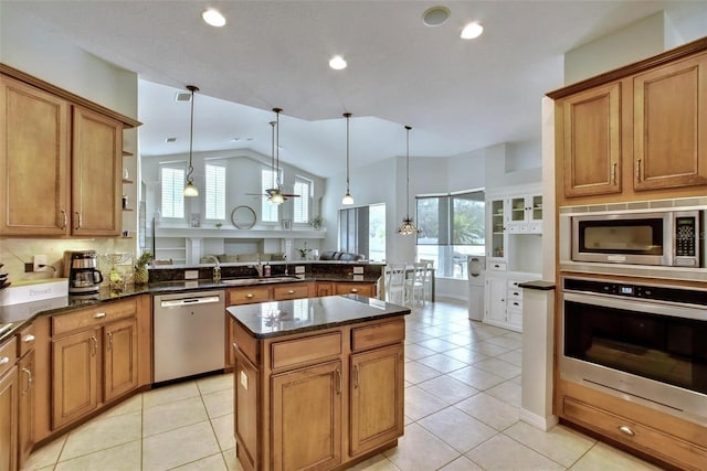 kitchen featuring light tile patterned floors, ceiling fan, appliances with stainless steel finishes, decorative light fixtures, and lofted ceiling