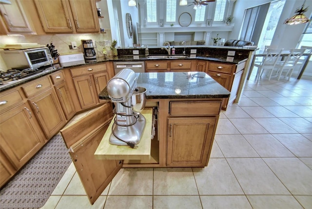 kitchen featuring light tile patterned floors, sink, and dark stone countertops