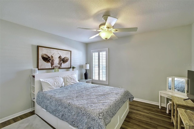 bedroom with ceiling fan, dark wood-type flooring, and a textured ceiling