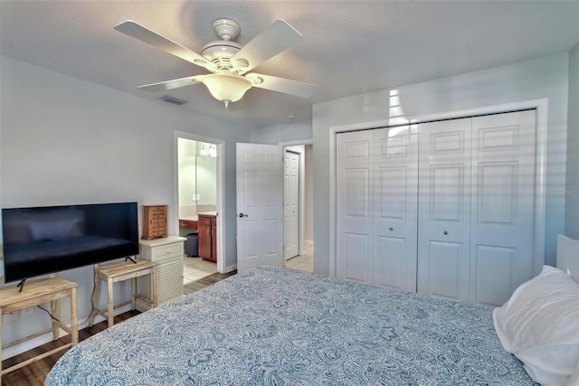 bedroom featuring ceiling fan, a closet, and ensuite bath