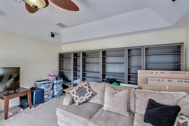 living room featuring a raised ceiling and carpet