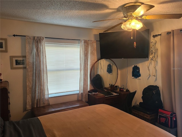 bedroom with ceiling fan and a textured ceiling