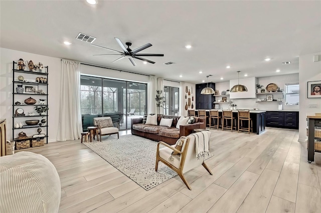 living room featuring ceiling fan and light hardwood / wood-style flooring