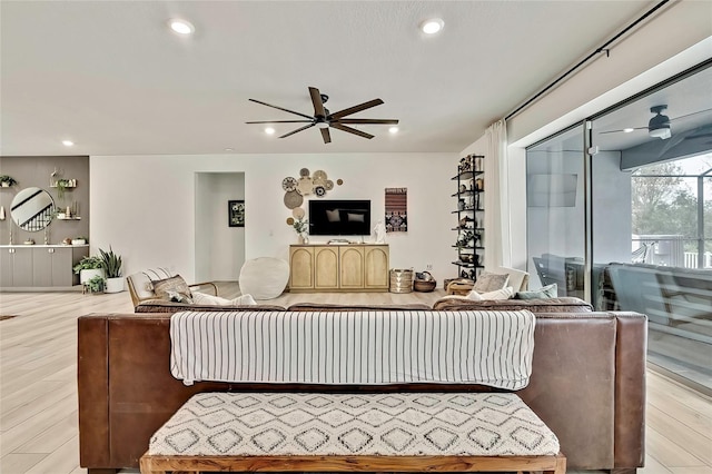 living room with ceiling fan and light hardwood / wood-style flooring