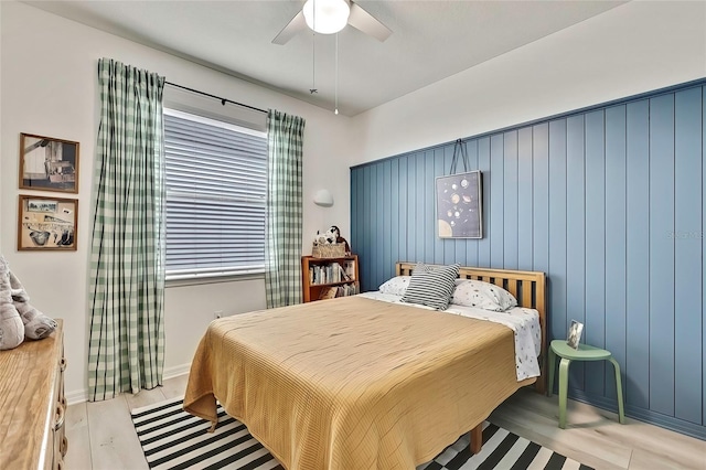 bedroom featuring ceiling fan, light hardwood / wood-style floors, and multiple windows