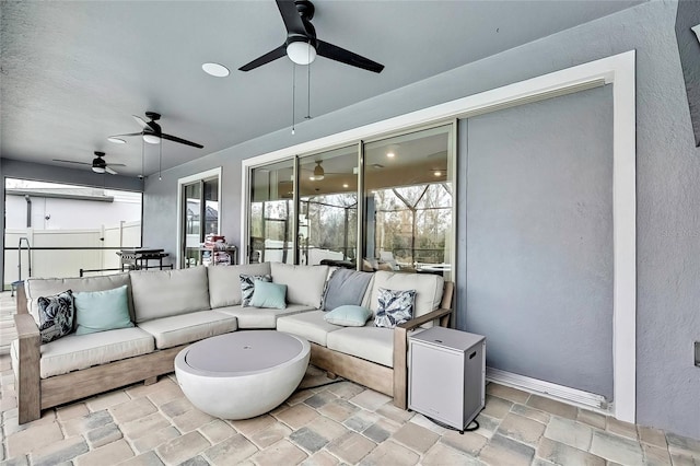 view of patio with an outdoor hangout area, ceiling fan, and glass enclosure