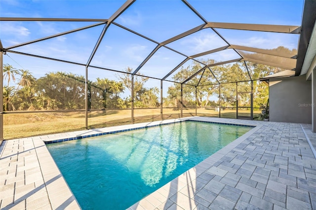 view of pool with a patio area and glass enclosure