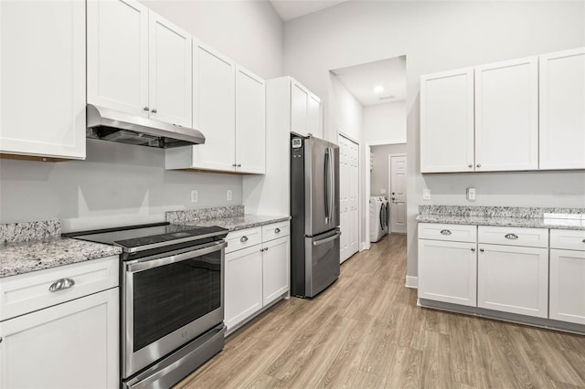 kitchen featuring white cabinets, stainless steel appliances, and washing machine and dryer