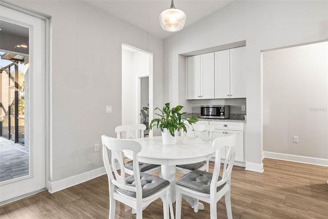 dining space featuring vaulted ceiling and hardwood / wood-style floors