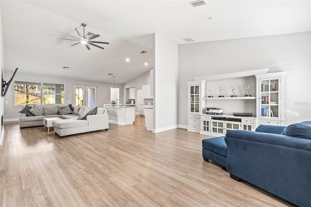 living room featuring ceiling fan, light wood-type flooring, and lofted ceiling