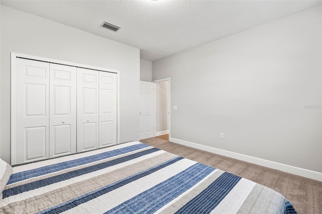 unfurnished bedroom featuring carpet, a closet, and a textured ceiling