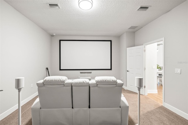 carpeted home theater room featuring a textured ceiling