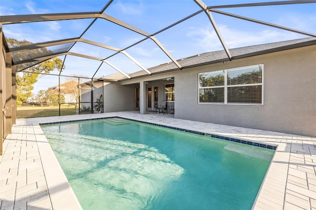 view of pool featuring glass enclosure and a patio