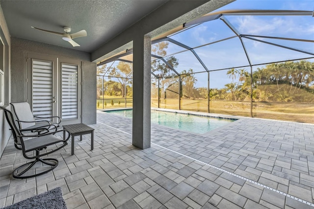 view of swimming pool featuring glass enclosure and a patio area