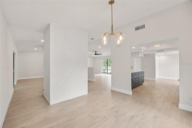 unfurnished room featuring light hardwood / wood-style floors and ceiling fan with notable chandelier