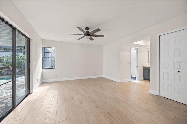 empty room with ceiling fan and light hardwood / wood-style flooring