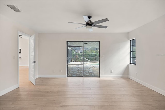 spare room featuring ceiling fan, a healthy amount of sunlight, and light hardwood / wood-style flooring