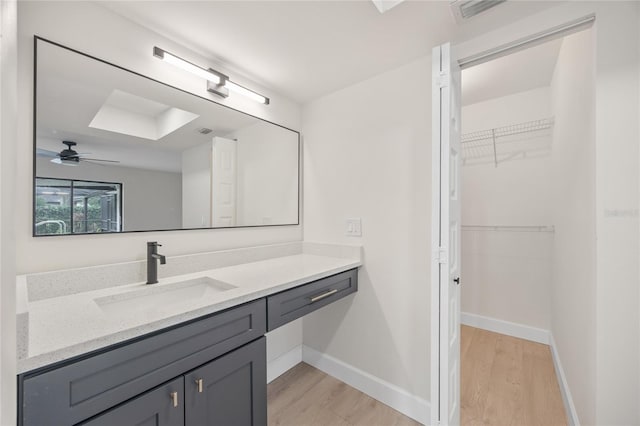 bathroom featuring ceiling fan, hardwood / wood-style floors, and vanity