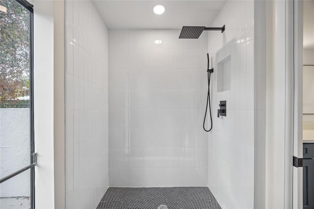 bathroom featuring tiled shower and vanity