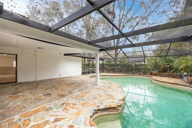 view of swimming pool featuring glass enclosure and a patio