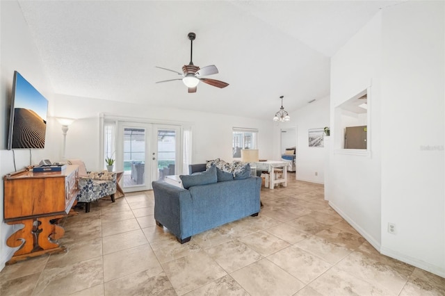 living room featuring ceiling fan with notable chandelier, french doors, and vaulted ceiling