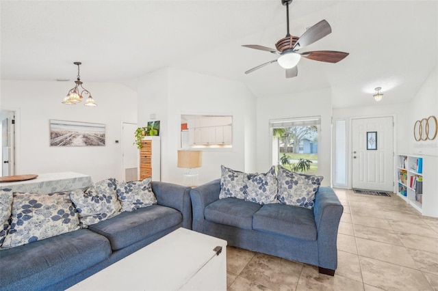 living room featuring ceiling fan with notable chandelier, lofted ceiling, and light tile patterned floors