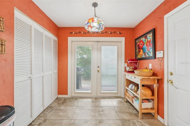 doorway with a textured ceiling, french doors, and light tile patterned floors