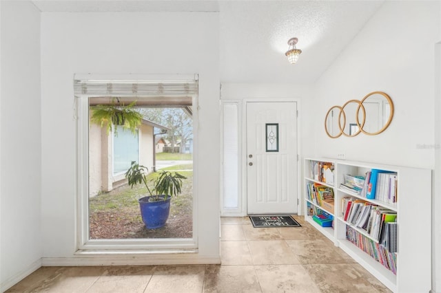 tiled foyer entrance featuring a textured ceiling