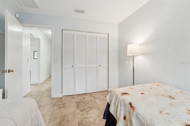 bedroom featuring a textured ceiling and a closet