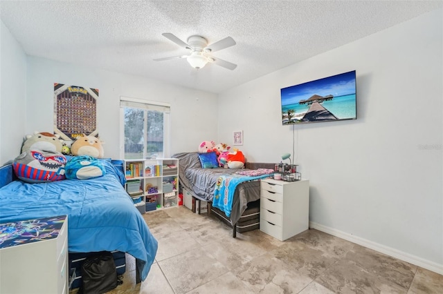 bedroom with ceiling fan and a textured ceiling