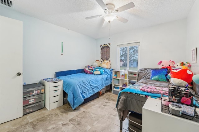 bedroom with ceiling fan and a textured ceiling