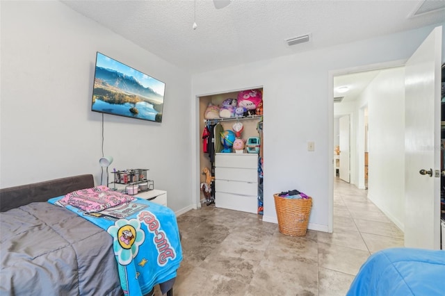 bedroom with ceiling fan, a closet, and a textured ceiling