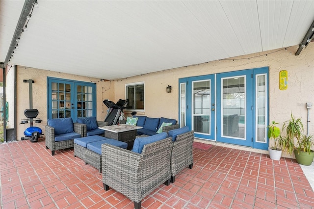 view of patio with french doors and an outdoor living space with a fire pit