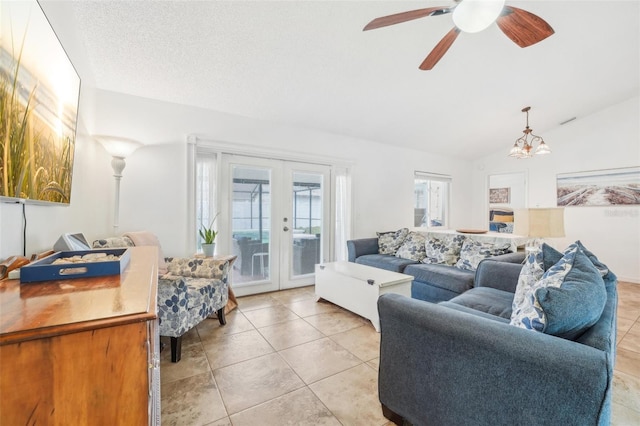 tiled living room featuring vaulted ceiling, a textured ceiling, ceiling fan, and french doors