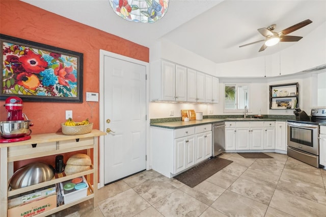 kitchen with vaulted ceiling, stainless steel appliances, ceiling fan, white cabinets, and sink