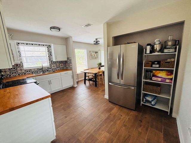 kitchen with wood counters, stainless steel fridge, dark hardwood / wood-style flooring, white cabinets, and sink