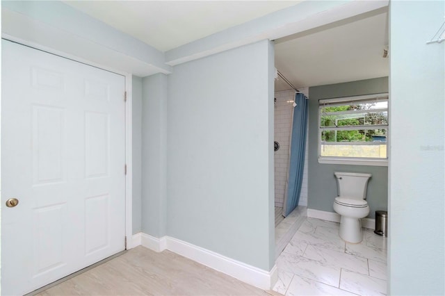 bathroom with a shower with curtain and toilet