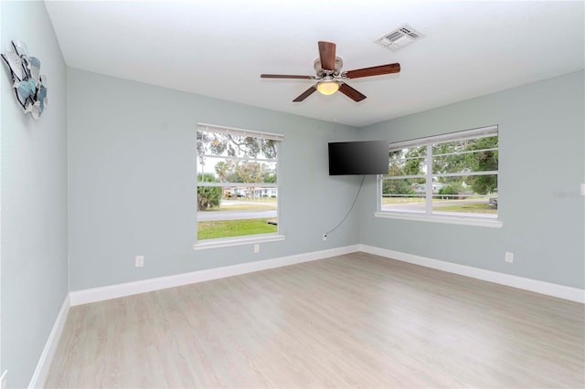 empty room featuring ceiling fan, light hardwood / wood-style flooring, and plenty of natural light